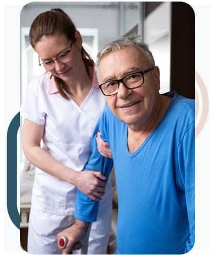 Smiling man with glasses and a blue shirt supported by a nurse